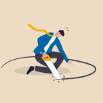 Business man sawing a hole under where he is standing